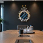 Een lege vergaderruimte van Club Brugge met een vast clubembleem op de wand.