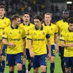 Een groep Union-spelers in gele wedstrijdtenues wandelt samen over het veld na een Europese wedstrijd.