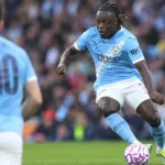 Jérémy Doku van Manchester City in actie in een lichtblauw shirt.