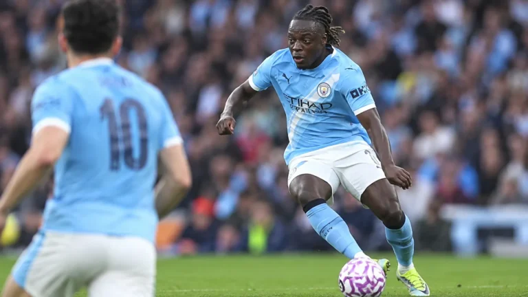 Jérémy Doku van Manchester City in actie in een lichtblauw shirt.