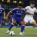 Een groep RSCA Futures-spelers in paarse tenues in actie tijdens een voetbalwedstrijd.