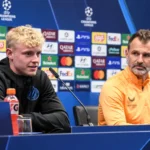 Twee persdeelnemers van Club Brugge aan tafel tijdens een persconferentie.