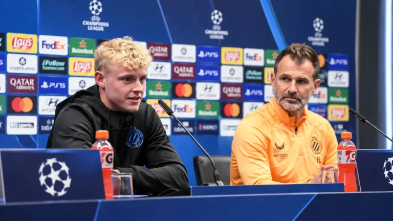 Twee persdeelnemers van Club Brugge aan tafel tijdens een persconferentie.