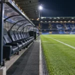 Lege technische zone aan het veld in het Jan Breydelstadion met een Club Brugge-embleem op de dug-out.