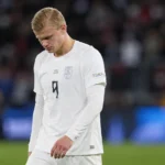 Erling Haaland in een wit Noors shirt op het veld.