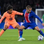 Een PSG-speler en een Barcelona-speler vechten om de bal tijdens een Champions League-wedstrijd.