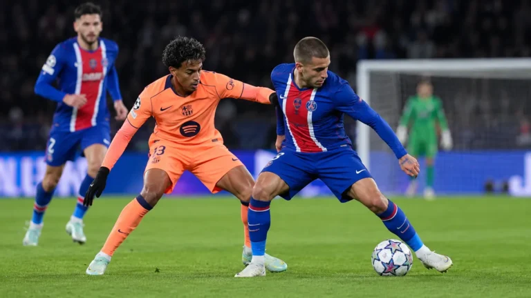 Een PSG-speler en een Barcelona-speler vechten om de bal tijdens een Champions League-wedstrijd.