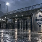 Regen bij de ingang van het stadion van Como met een Como-embleem op een vast bord.