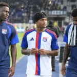 Drie spelers van Olympique Lyonnais lopen naast het veld in hun clubtenue.