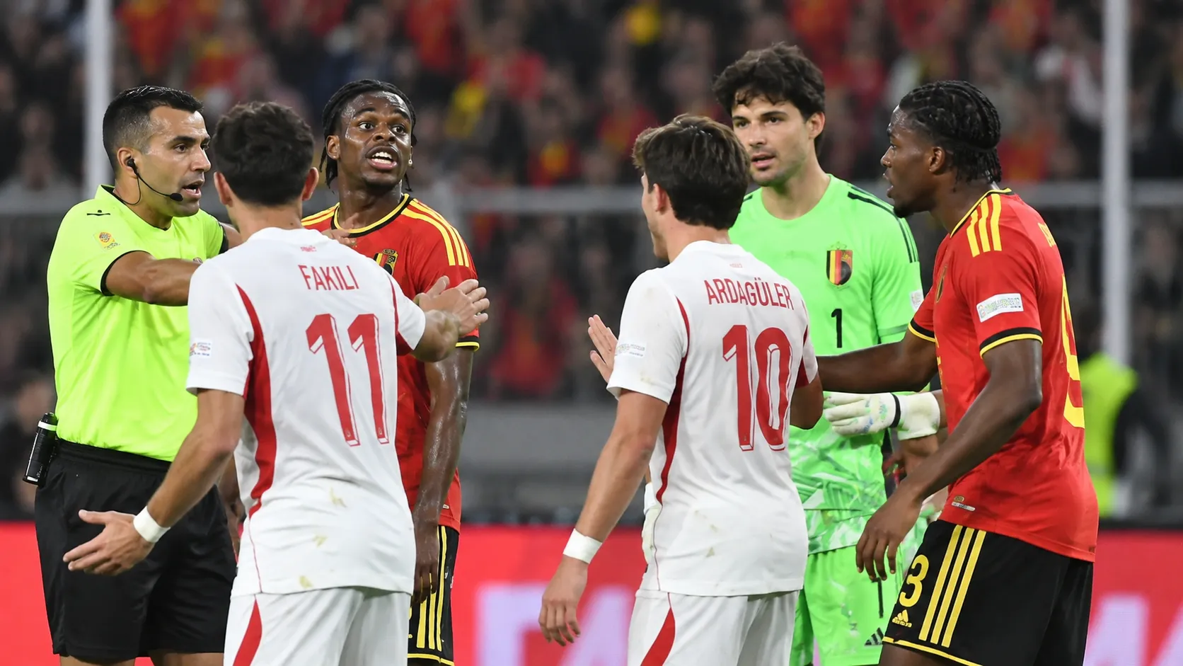 Spelers van België en Turkije in discussie met de scheidsrechter tijdens een wedstrijdmoment.