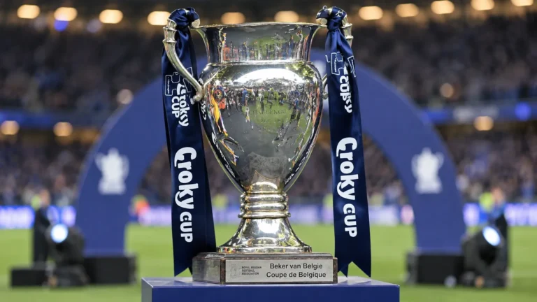 De Croky Cup-trofee met donkerblauwe linten in een voetbalomgeving.