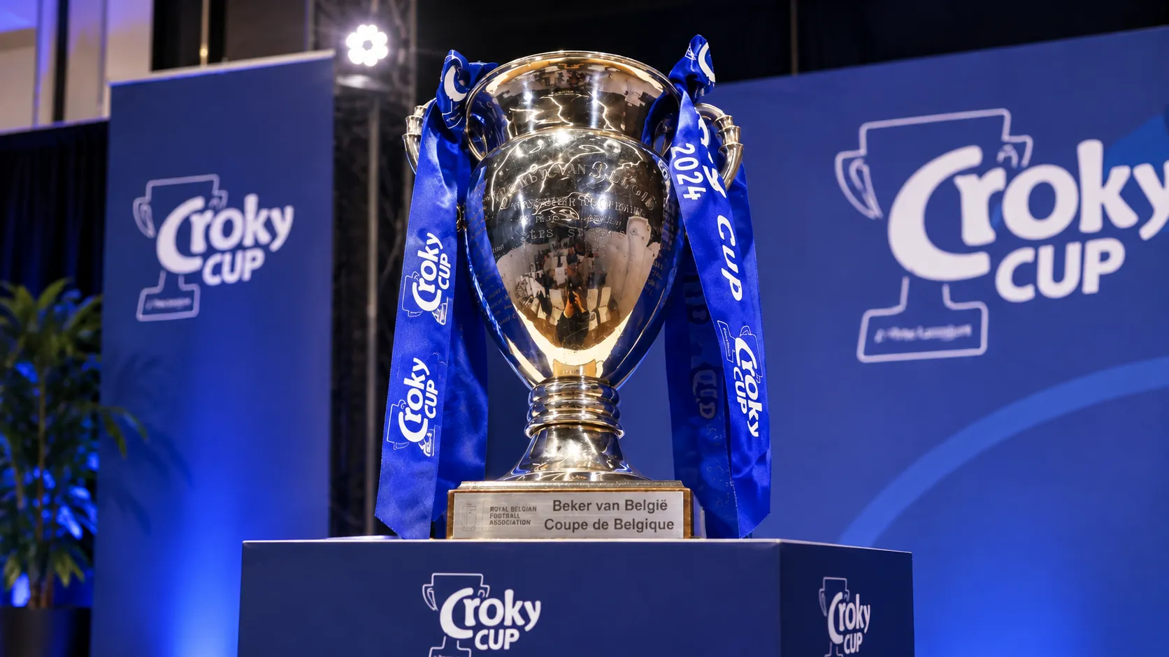 De Beker van België op een officieel Croky Cup-podium met blauwe linten.