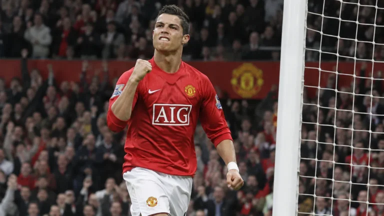 Cristiano Ronaldo viert in een rood Manchester United-tenue nabij het doel.
