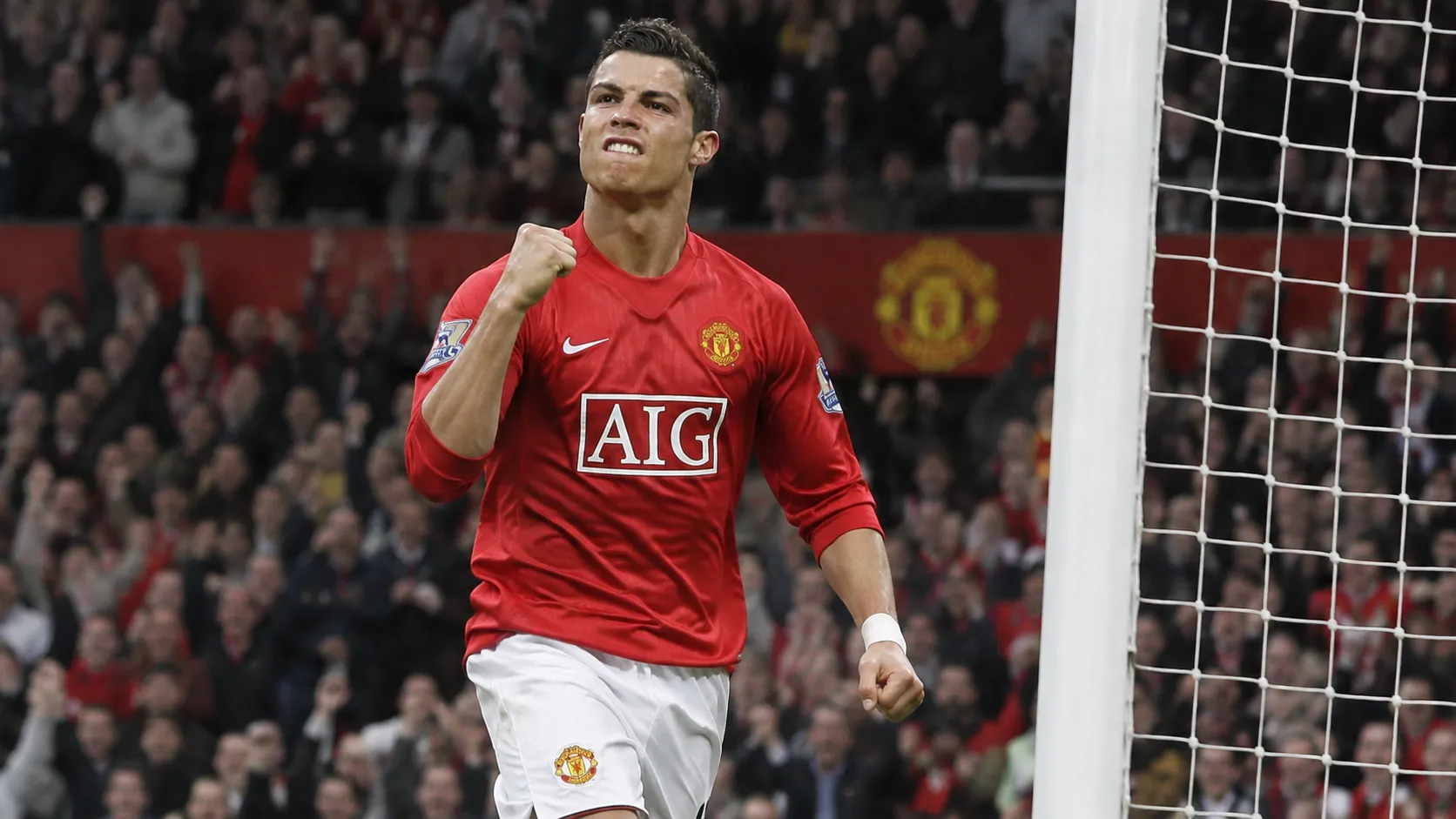Cristiano Ronaldo viert in een rood Manchester United-tenue nabij het doel.