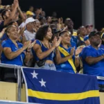 Collectieve supporters van Curaçao met een nationale vlag in de tribunes.