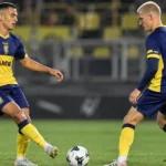 Twee spelers in blauw-geel tenue tijdens een technisch voetbalmoment.