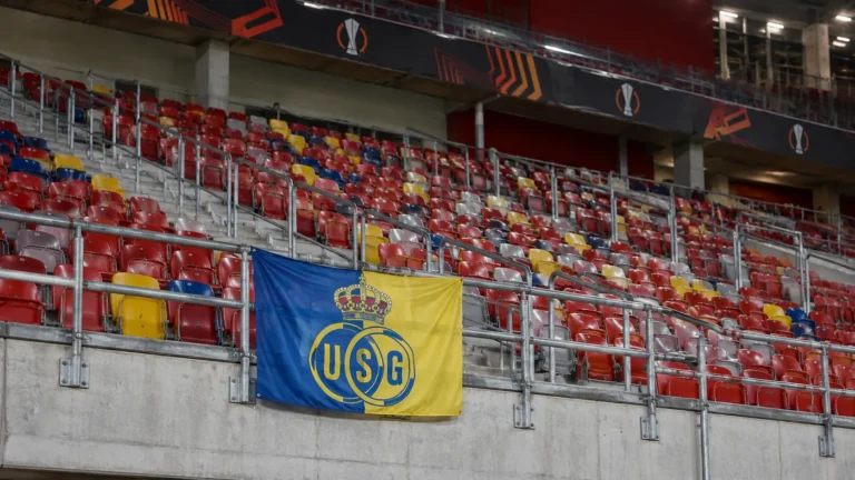 Een leeg stadionvak met een fysiek geïntegreerde Union SG-banner aan de balustrade.