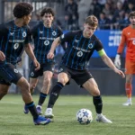 Club NXT-spelers in zwart-blauw tijdens een Youth League-wedstrijd.