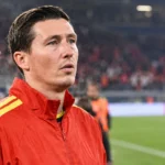 Hans Vanaken in een rode sportjas aan de rand van het veld na de match.