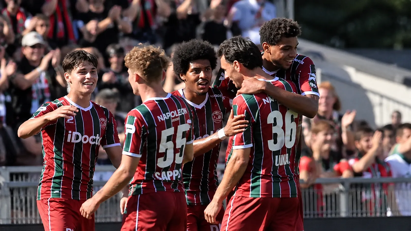 Een groep spelers van Zulte Waregem viert samen voor de tribune.