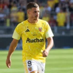 Thorgan Hazard in het gele tenue van RC Lens op het veld.