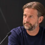 Rik De Mil in een KAA Gent-trainingsshirt tijdens een gesprek met de media.