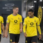 Een groep Dortmund-spelers in gele wedstrijdshirts wandelt na een match naar de spelersbus.