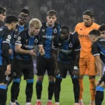 Club Brugge-spelers verzamelen zich in de regen op het veld voor de tweede helft.