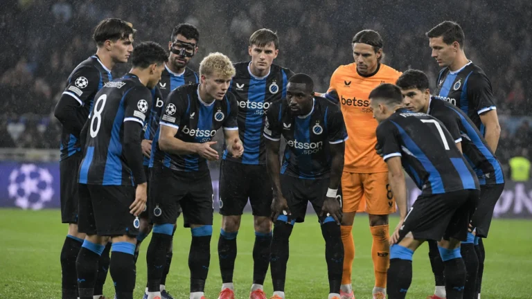 Club Brugge-spelers verzamelen zich in de regen op het veld voor de tweede helft.