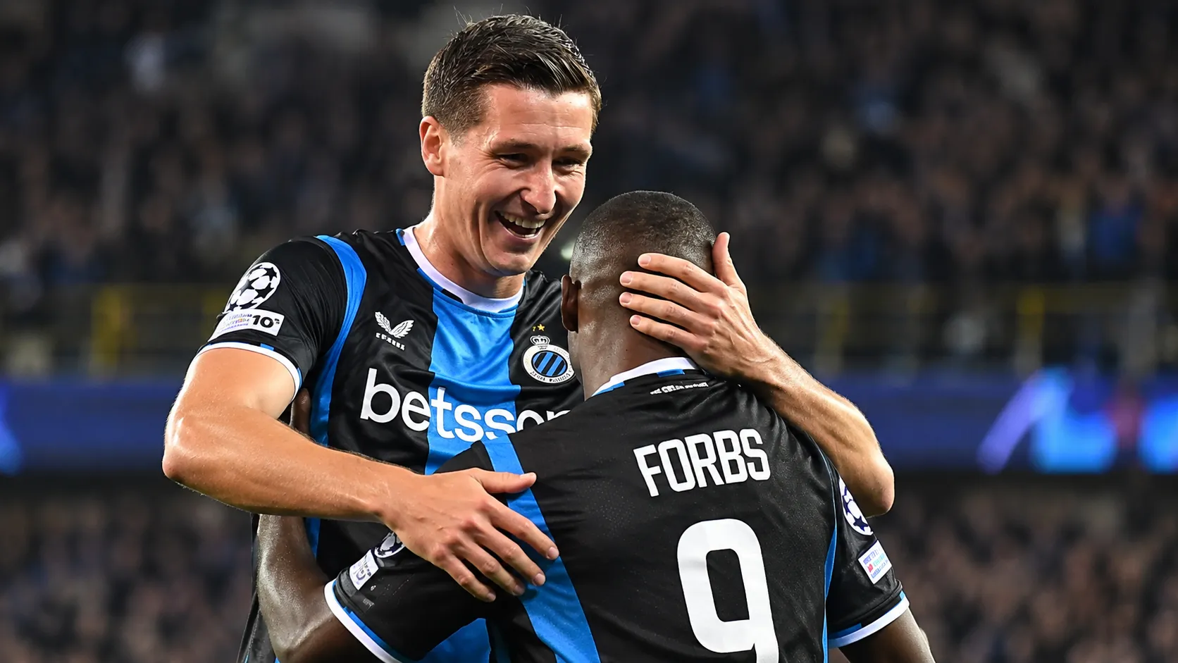 Twee spelers van Club Brugge vieren samen een doelpunt in een Champions League-wedstrijd.