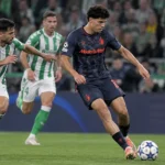Een Feyenoord-speler in donker tenue tijdens een wedstrijdmoment tegen Real Betis.