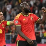 Romelu Lukaku viert op het veld in een rood Belgisch shirt naast een ploegmaat.
