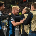 Spelers en staf van Club Brugge vieren samen naast het veld.