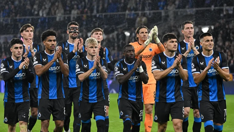 Spelers van Club Brugge applaudisseren na afloop op een regenachtig veld.