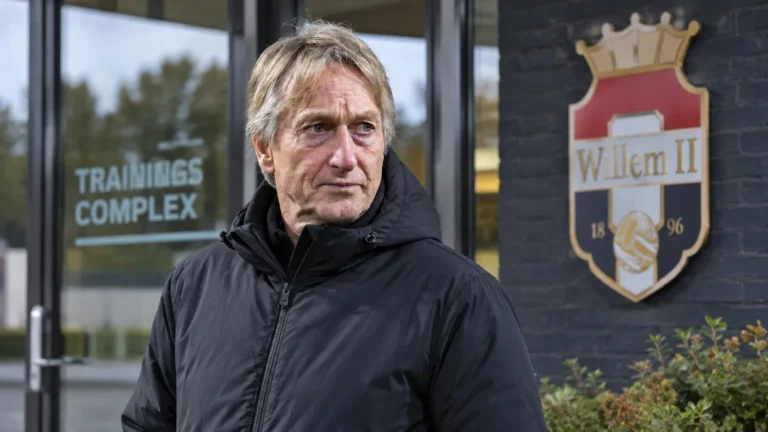 Adrie Koster in een neutrale jas aan de ingang van het trainingscomplex van Willem II.