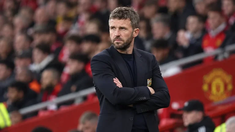 Een Manchester United-coach in donkere kleding langs de zijlijn tijdens een wedstrijd.