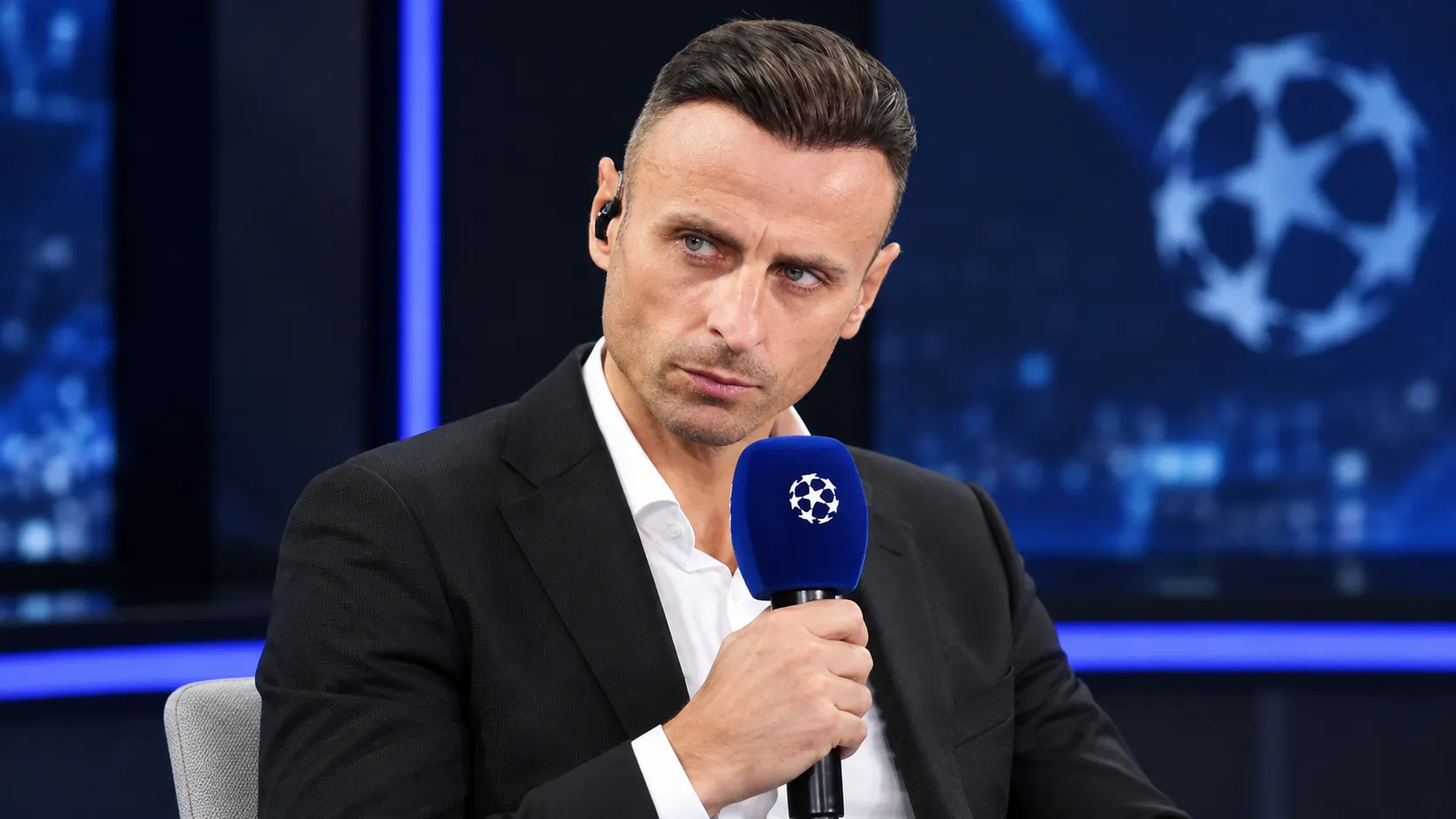 Dimitar Berbatov met een blauwe Champions League-microfoon in een televisiestudio.