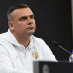 Adrian Siemieniec in een witte sporttrui tijdens een persmoment voor de wedstrijd.