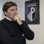 Luc Nilis in een kantoor van Patro Eisden bij een bord voor de sportieve werking.
