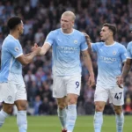 Een groep Manchester City-spelers in lichtblauwe tenues op het veld.
