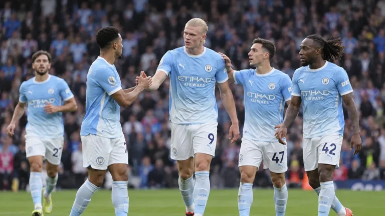 Een groep Manchester City-spelers in lichtblauwe tenues op het veld.