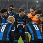 Een groep spelers van Club Brugge in blauw-zwarte wedstrijdshirts op een regenachtige Europese voetbalavond.