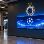 Een verlicht wedstrijdbord van Club Brugge in een lege stadionconcourse.