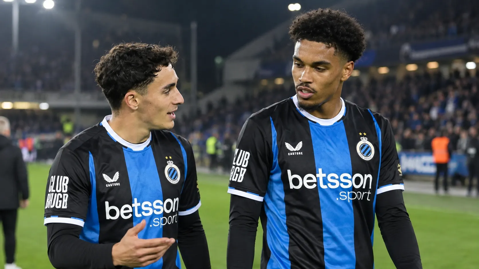 Twee Club Brugge-spelers wandelen samen over het veld na de wedstrijd.