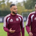 Een groep Anderlecht-spelers in bordeaux trainingskleding tijdens een training op een buitenveld.