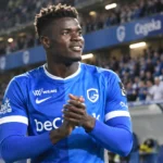 Aaron Bibout in het blauwe shirt van KRC Genk aan de rand van het veld.