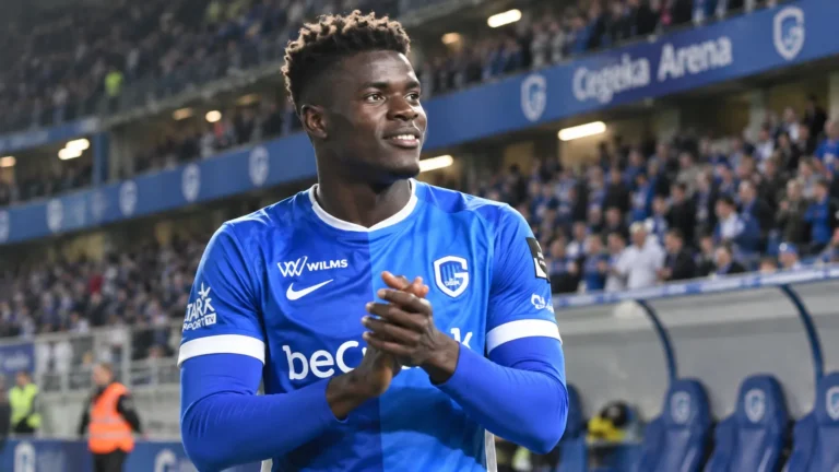 Aaron Bibout in het blauwe shirt van KRC Genk aan de rand van het veld.