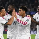 Een groep Real Madrid-spelers in witte wedstrijdtenues viert samen op het veld.