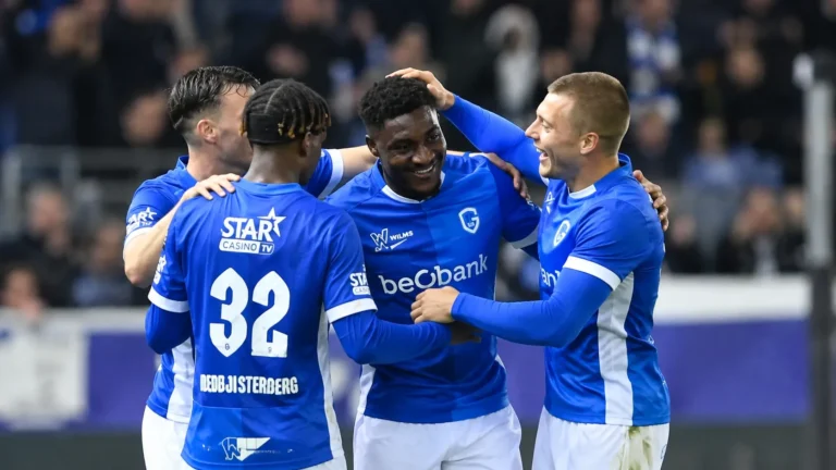 Spelers van KRC Genk vieren samen een doelpunt op het veld.