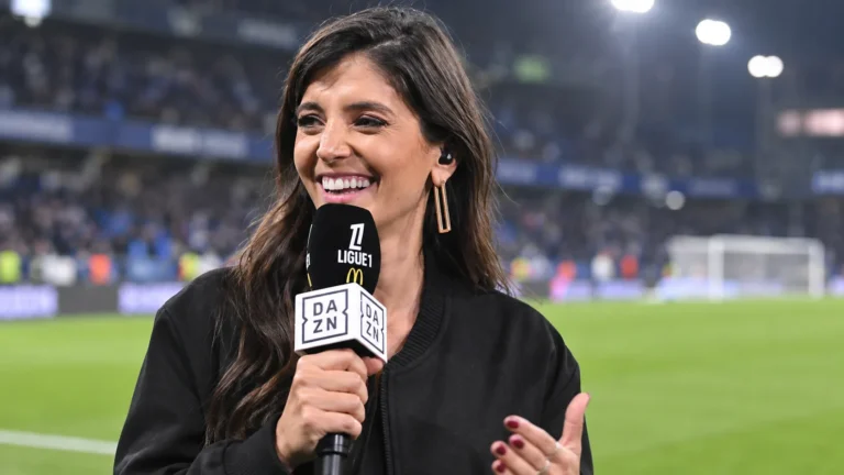 Séverine Parlakou als voetbalpresentatrice met een DAZN-microfoon aan de rand van een voetbalveld.